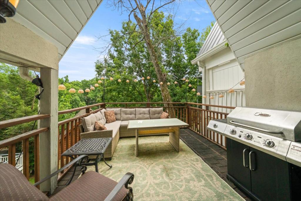 eine Terrasse mit einem Sofa und einem Tisch auf einer Terrasse in der Unterkunft Relax at Forge Chalet Tranquil Retreat Near Attractions in Pigeon Forge