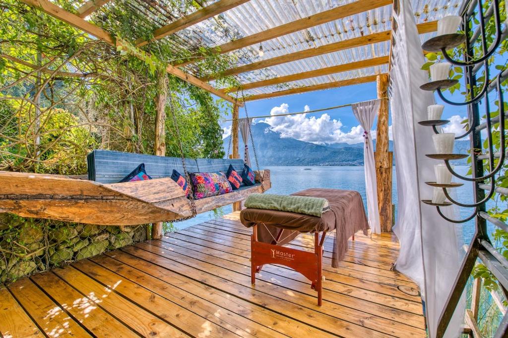 a hammock on a deck with a view of the water at 2-story Lakefront castita, beach, kitchen, sauna in Sololá