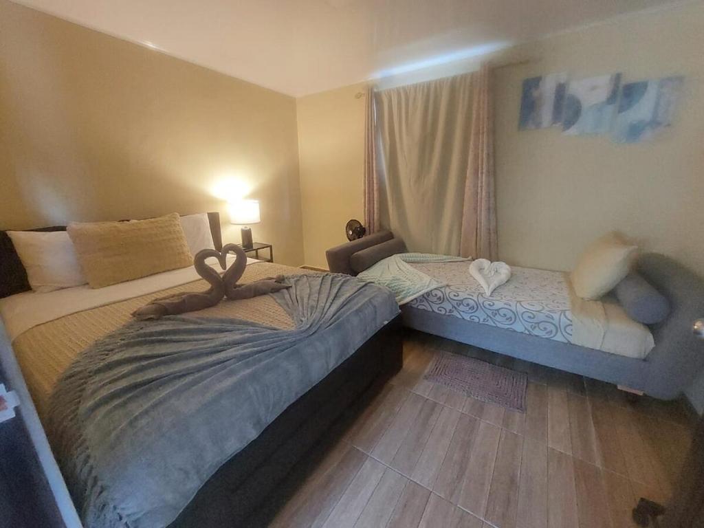 a bedroom with two beds and a couch and a window at Casa de campo disfruta del clima Paso Ancho Volcán in Paso Ancho