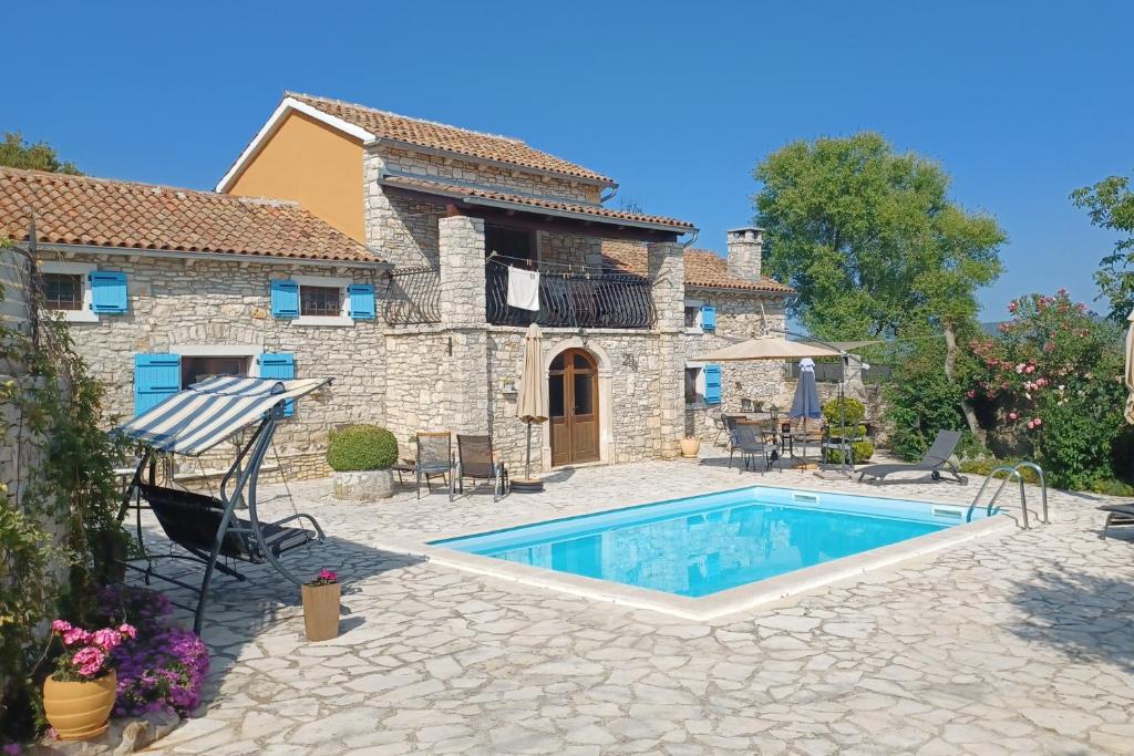 a villa with a swimming pool in front of a house at Family friendly house with a swimming pool Barban, Central Istria - Sredisnja Istra - 24471 in Barban