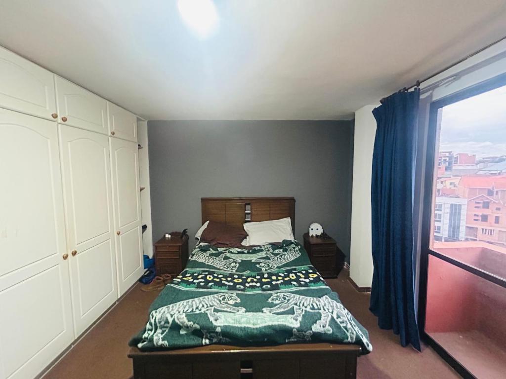 ein Schlafzimmer mit einem Bett und einem großen Fenster in der Unterkunft Hermoso Depto in La Playa Bejarano