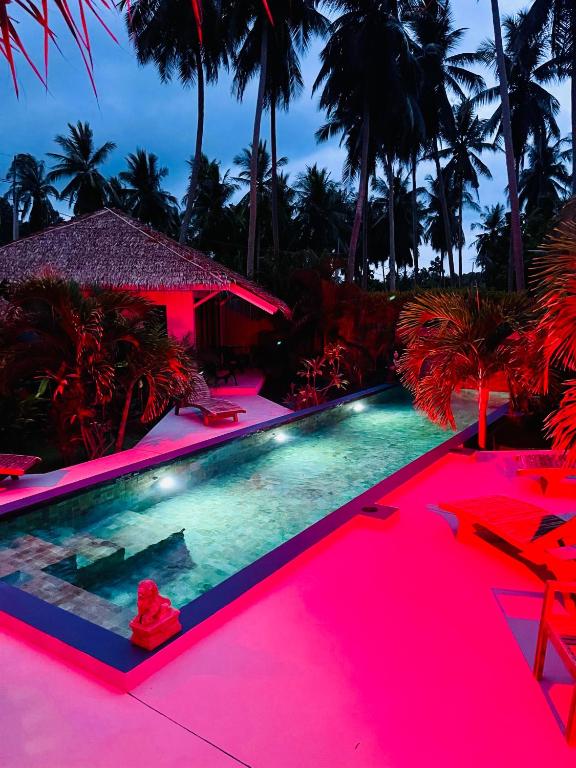 a swimming pool with pink lighting in front of a house at Surya Villa in Ko Phangan