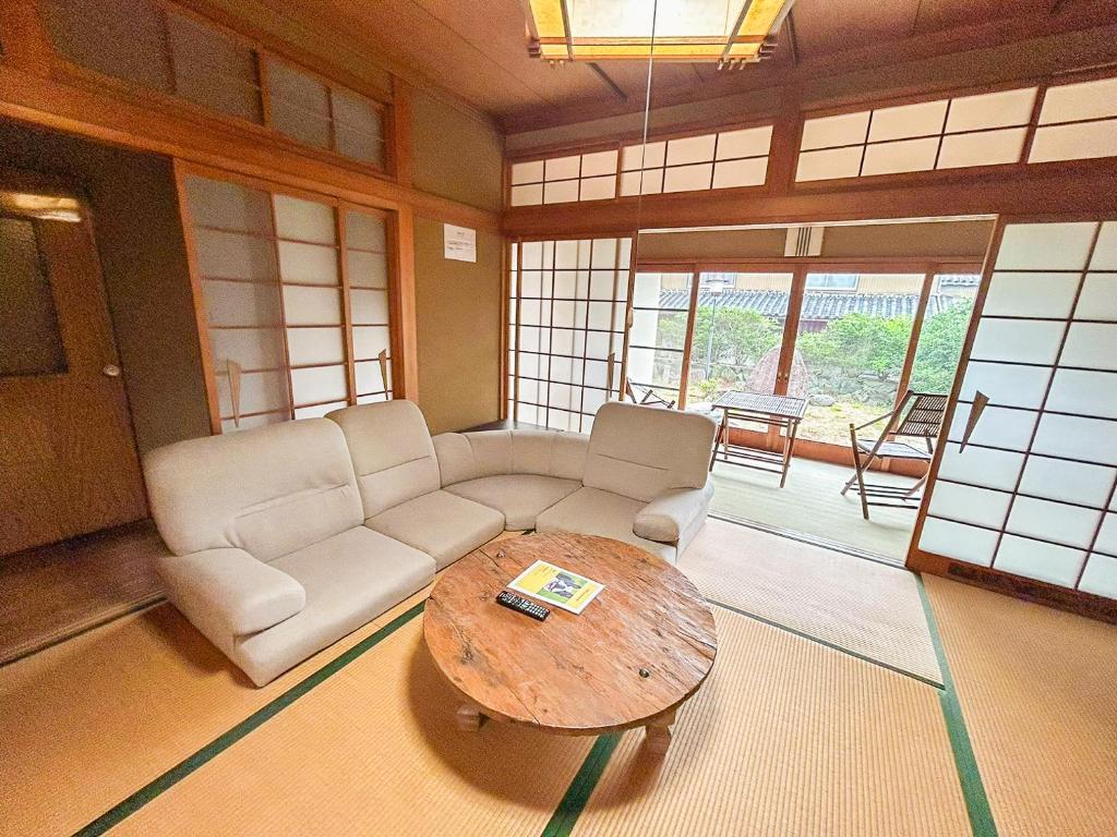 ein Wohnzimmer mit einer Couch und einem Couchtisch in der Unterkunft 癒しの宿 Villa ZEN 讃岐白鳥 in Higashikagawa