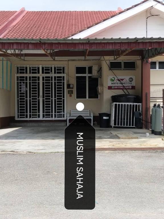 a sign in the street in front of a house at Wafiy Homestay in Macang