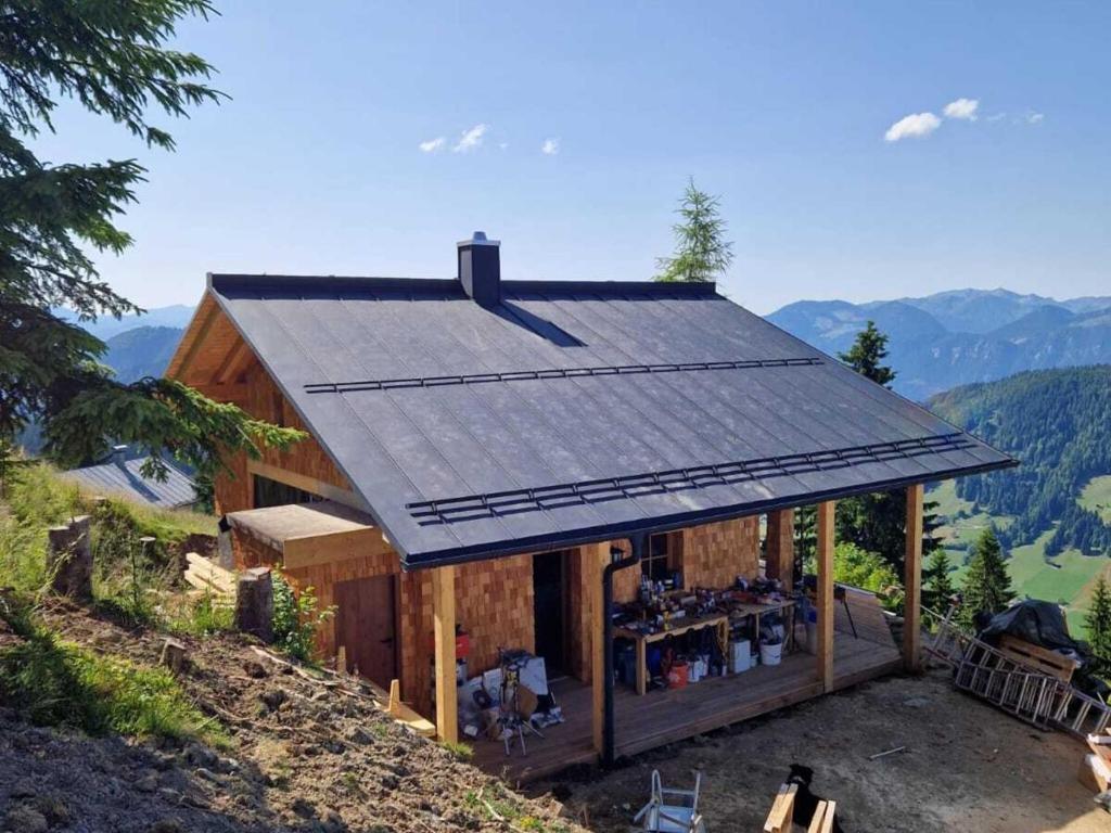 ein Haus mit einem Sonnendach auf einem Berg in der Unterkunft Panoramic hut in the ski area in Grafenweg