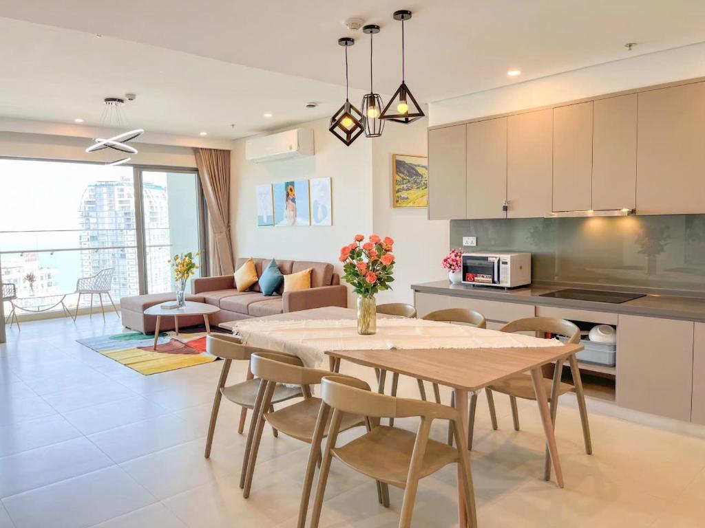 a kitchen and living room with a table and chairs at The Sóng Căn Hộ nằm cạnh Biển -An's Homestay in Vung Tau