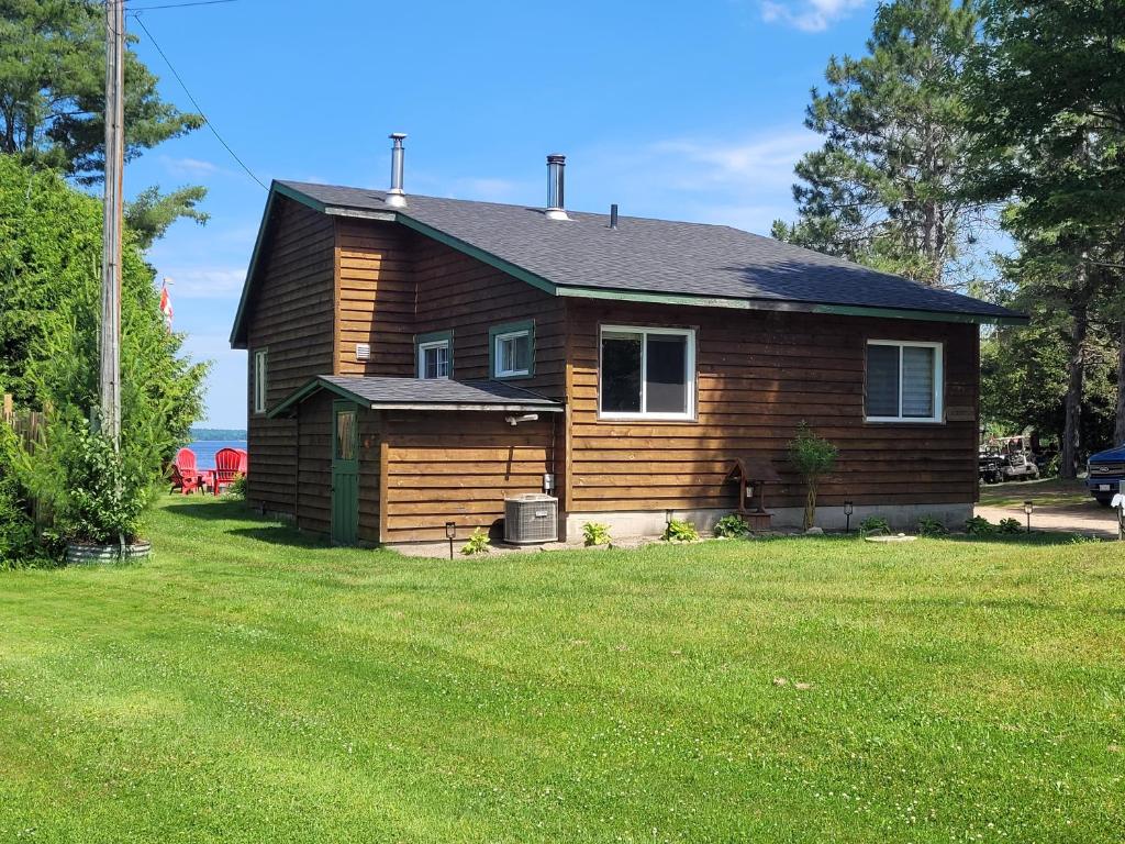 a small house with a grass yard in front of it at Pine Ridge Park Campground in Pembroke
