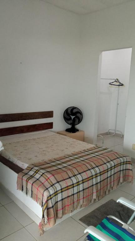 a bedroom with a bed with a blanket on it at Suites de frente pra praia in Itapemirim