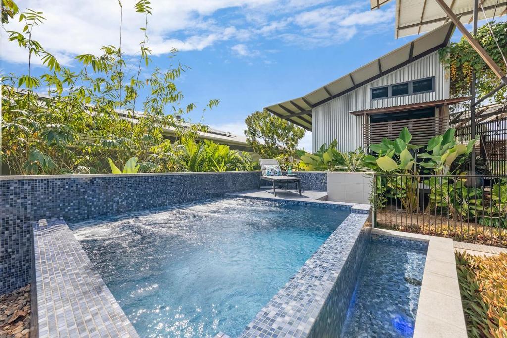 an infinity pool in the backyard of a house at Tropic Pavilion - Breezy Designer Retreat near Beach in Paraparap