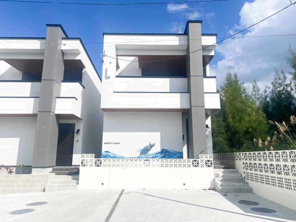 a white house with a fence in front of it at MIRATIO Saphir in Onna