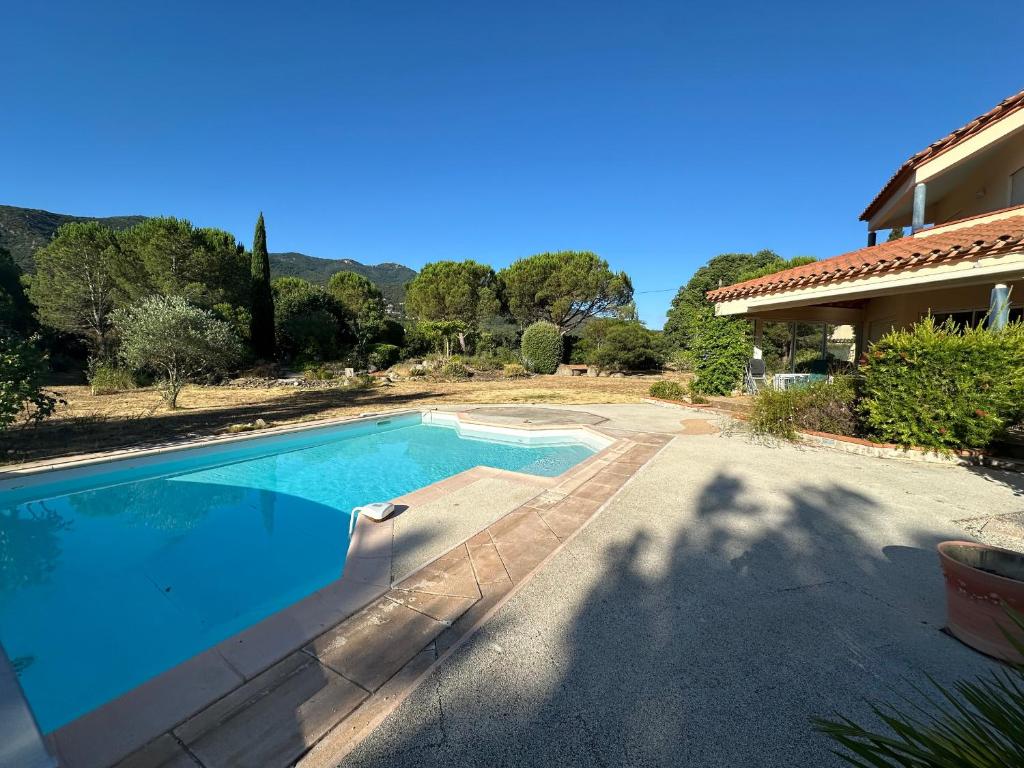 une piscine devant une maison dans l'établissement Villa 4 Faces à Laroque-des-Albères avec Piscine et Terrasse - FR-1-732-67, à Laroque-des-Albères