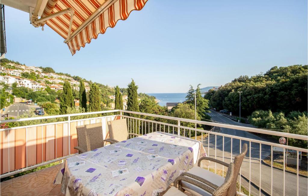 Un patio con una mesa y sillas en un balcón. en Lovely Apartment In Rabac With Wi-Fi, en Rabac