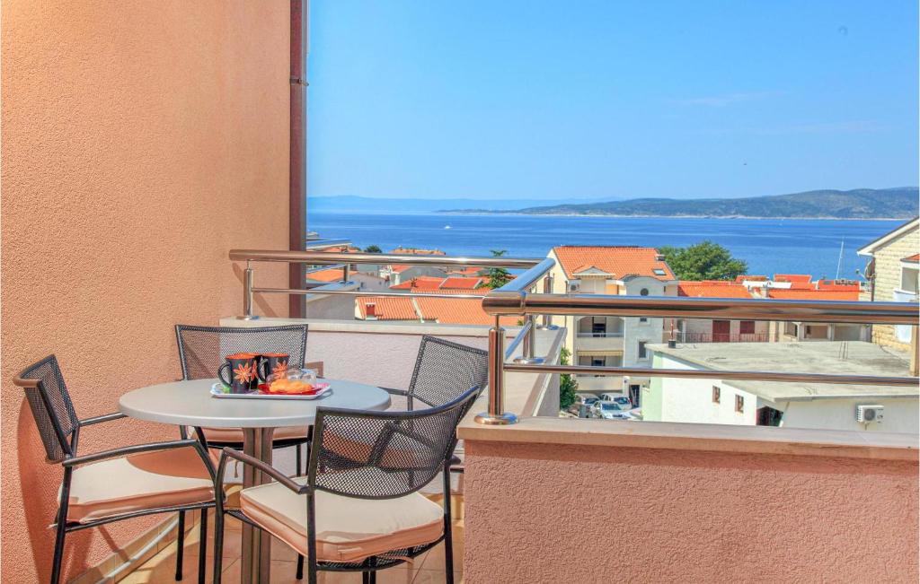 a table and chairs on a balcony with a view of the ocean at Beautiful Apartment In Baska Voda in Baška Voda