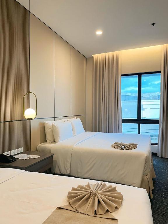 a hotel room with two beds and a large window at ILOILO GRAND HOTEL in Iloilo City