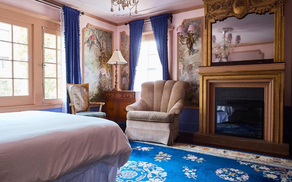ロサンゼルスにあるLuxurious Hollywood Homestayのベッドルーム(ベッド1台、暖炉、椅子付)
