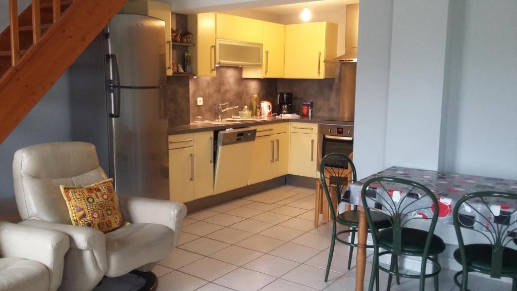 a kitchen with yellow cabinets and a table and chairs at Appartement Village Le Liberty 1 Argelès Sur Mer 2km plage in Argelès-sur-Mer