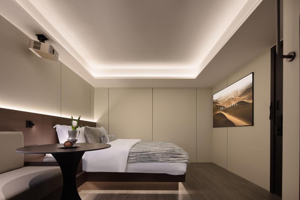 a bedroom with a bed and a table at Enji M Hotel (Guanyinqiao Branch) in Chongqing