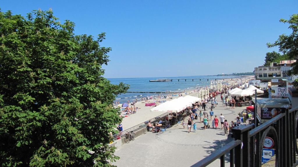 a crowd of people on a beach with umbrellas at Apartament Żeglarski in Kołobrzeg