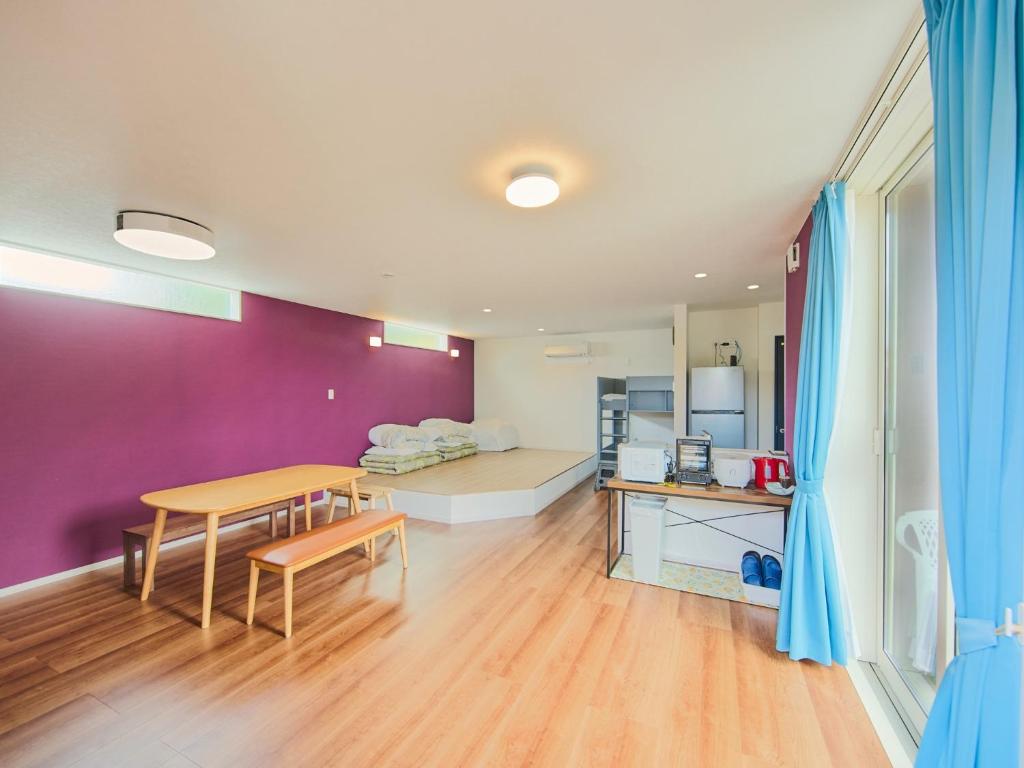 a living room with a table and a purple wall at Chocotto Villa Maestro - Vacation STAY 74566v in Sumoto