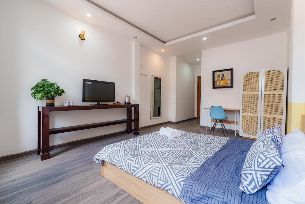 Un dormitorio con una cama, un escritorio y un televisor. en NEWROOM-1km 2 Bui Vien, en Ho Chi Minh
