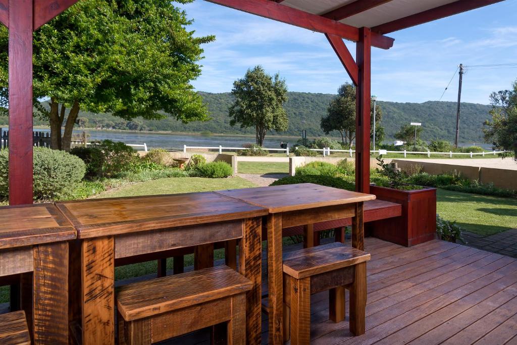 a wooden deck with a wooden table and benches at Estuary Breeze in Sedgefield