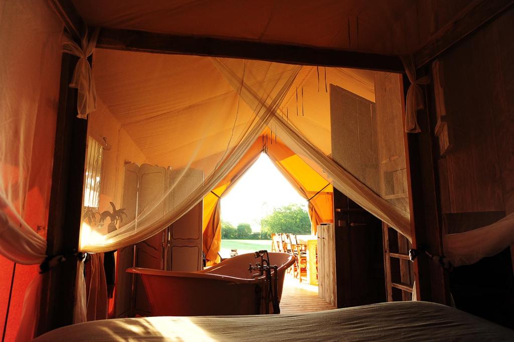 um quarto com uma tenda com uma cama em Kimaro Farmhouse em Colméry