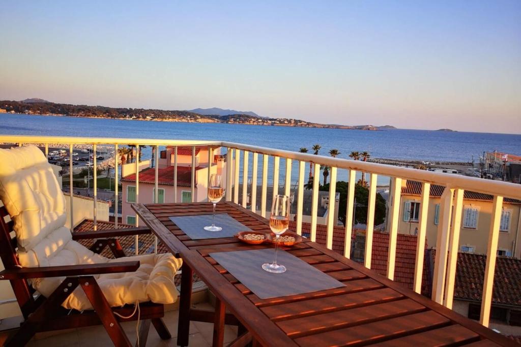 Una mesa y sillas en un balcón con vista al mar. en La trouvaille - port et mer grand balcon parking, en Bandol
