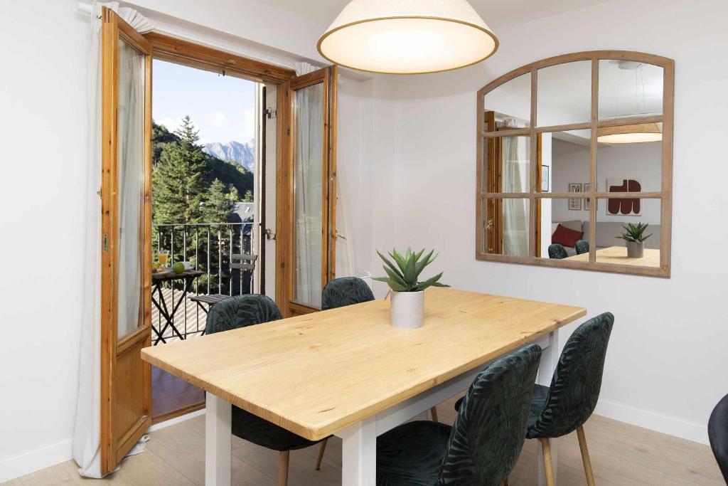 a dining room with a table and chairs and a mirror at Casa Josephine by BeValle in Panticosa