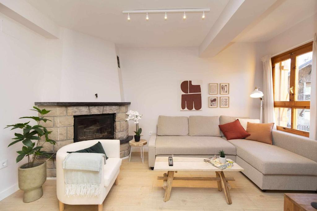 un soggiorno con divano e camino di Casa Josephine by BeValle a Panticosa