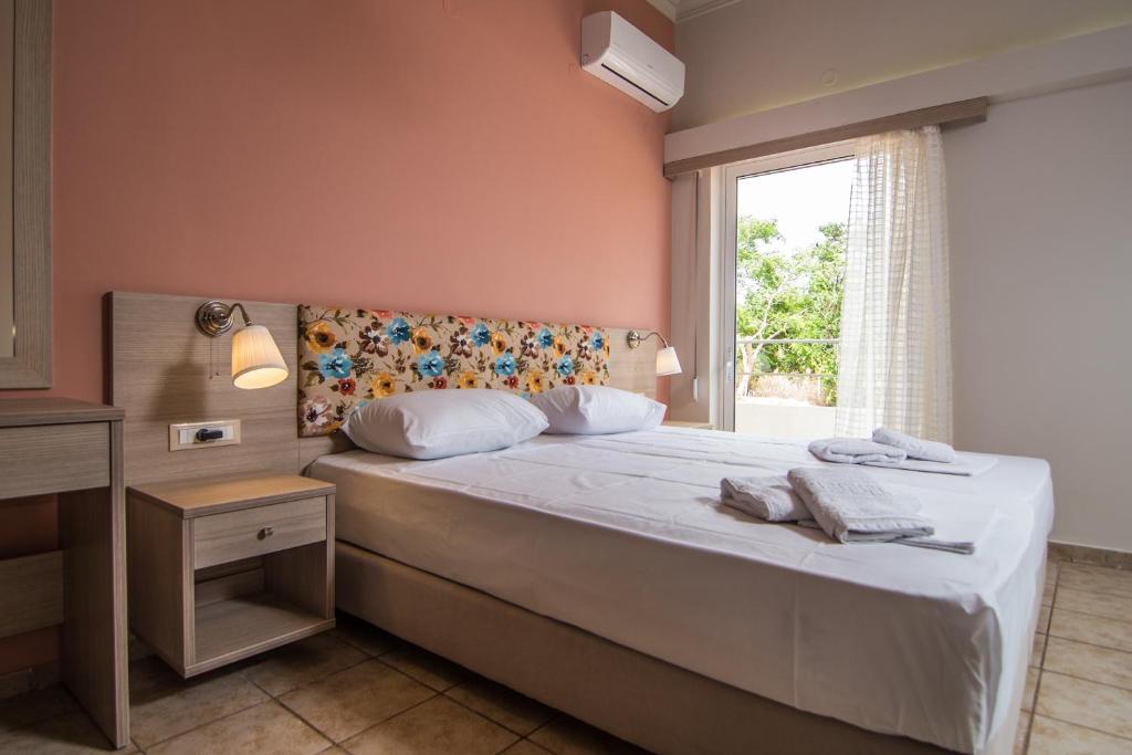 a bedroom with a large bed with a window at Grameno Apartments in Kountoura Selino