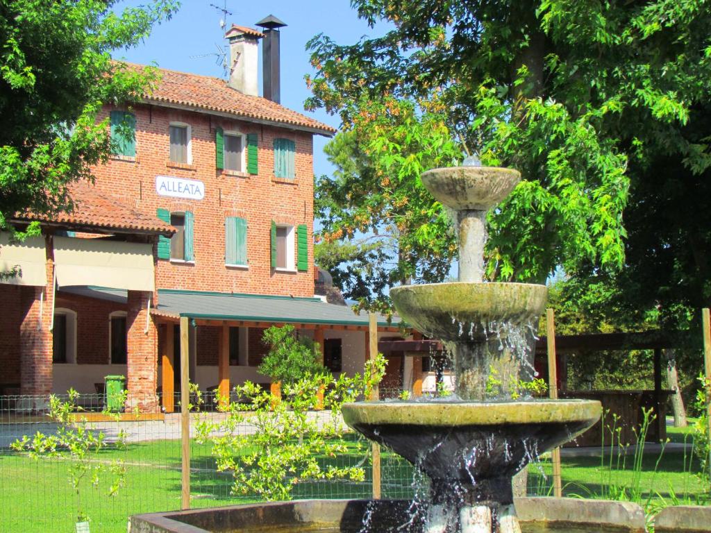a fountain in the middle of a park with a building at Agriturismo Ca' Alleata in Caorle