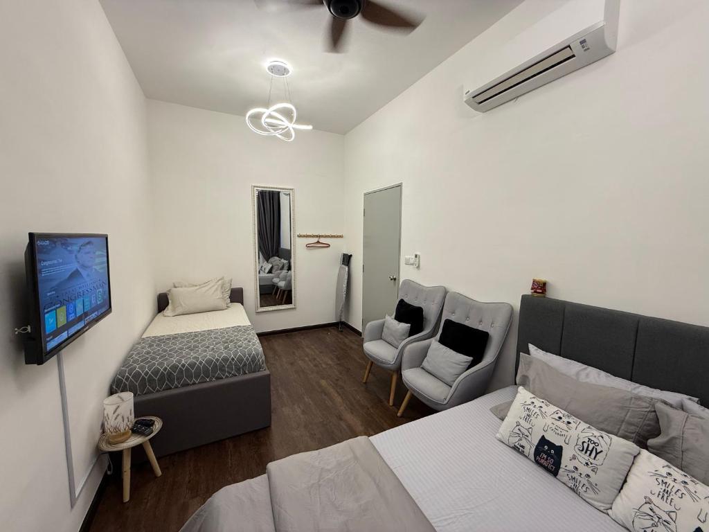 Un dormitorio con una cama, un televisor y un sofá. en Little Heaven Homestay Nilai, en Nilai