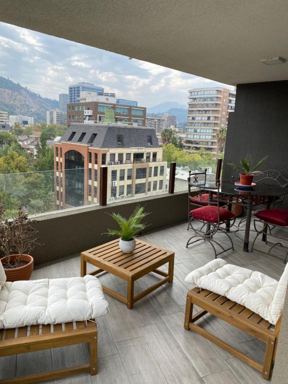 Winery Home Apartment في سانتياغو: شرفة مع أرائك وإطلالة على المدينة