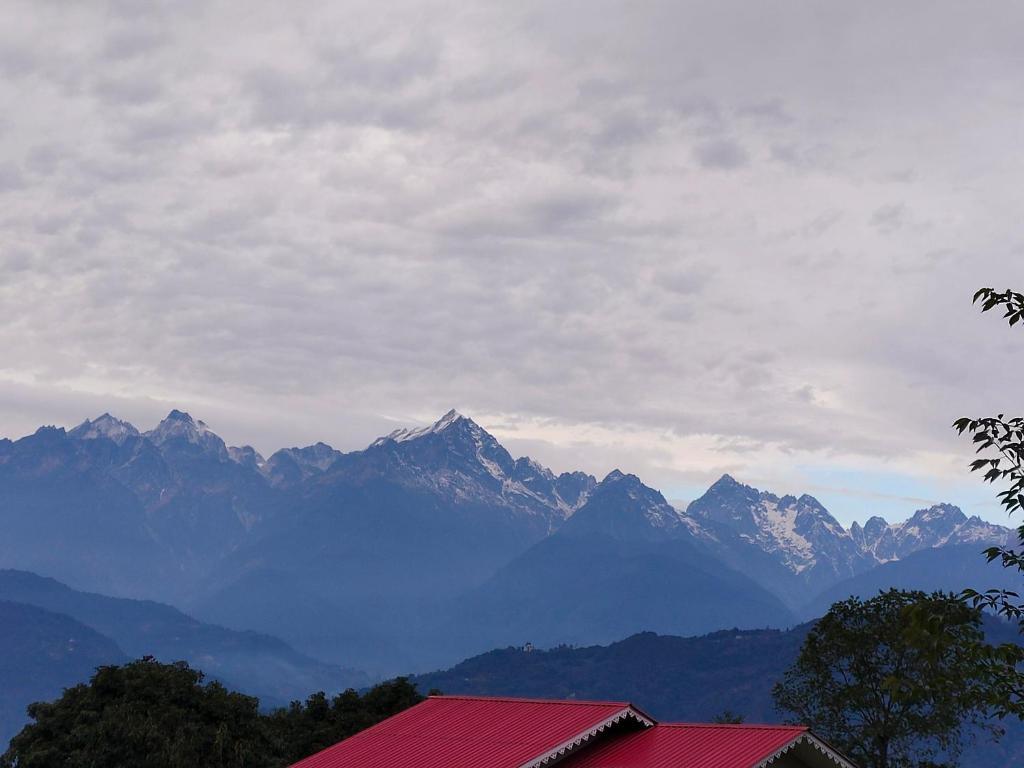 a view of a mountain range with a red roof at Tenzing's homestay in Sosing