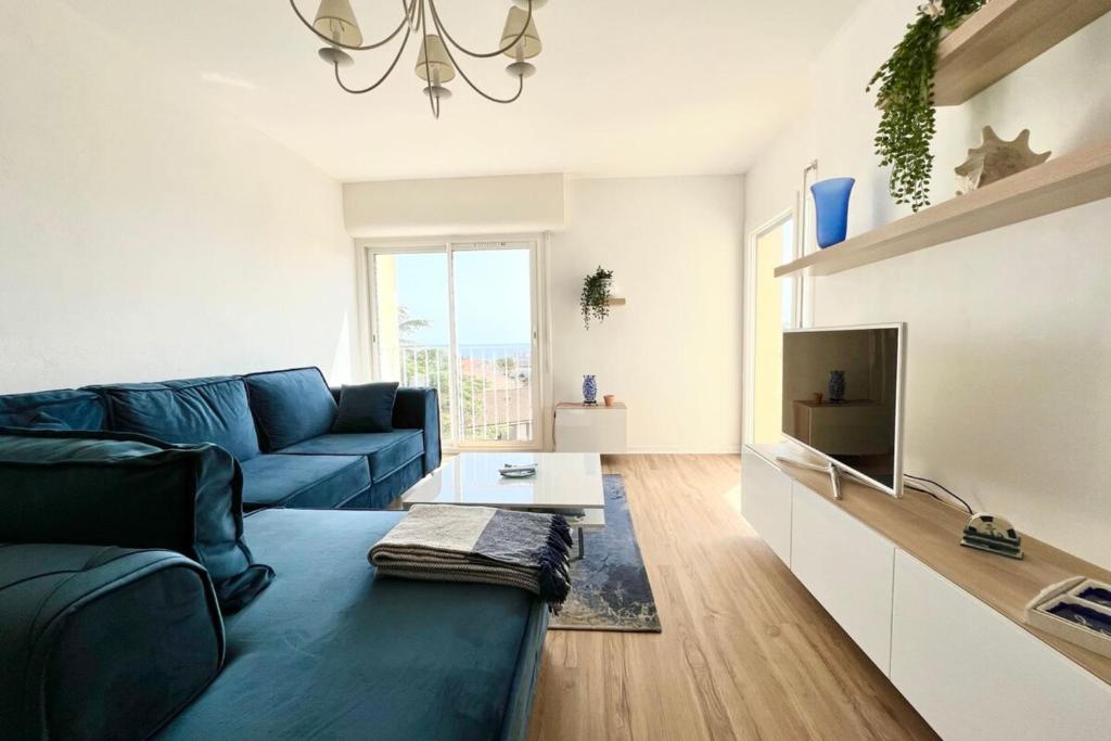 un salon avec un canapé bleu et une télévision dans l'établissement Grand appartement refait à neuf belle vue mer, à Bandol