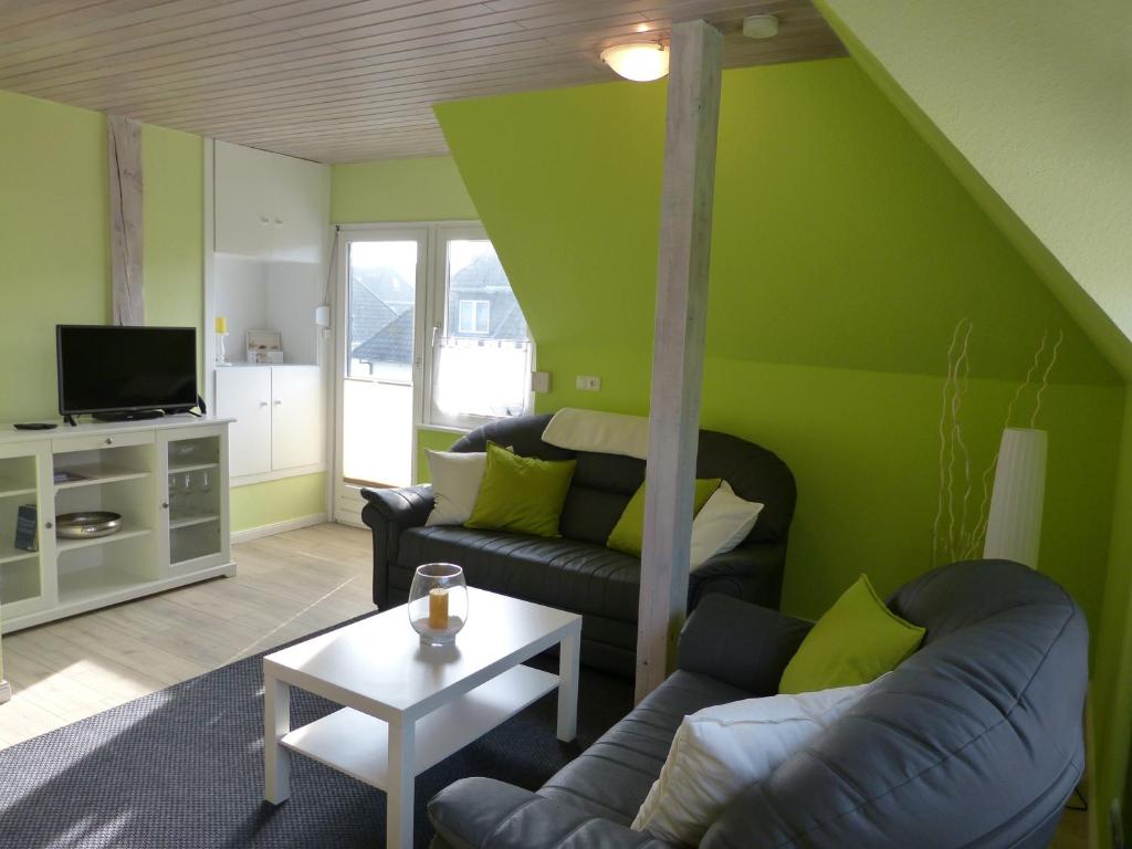 un soggiorno con pareti verdi e divano di Gästehaus Freya a Büsum