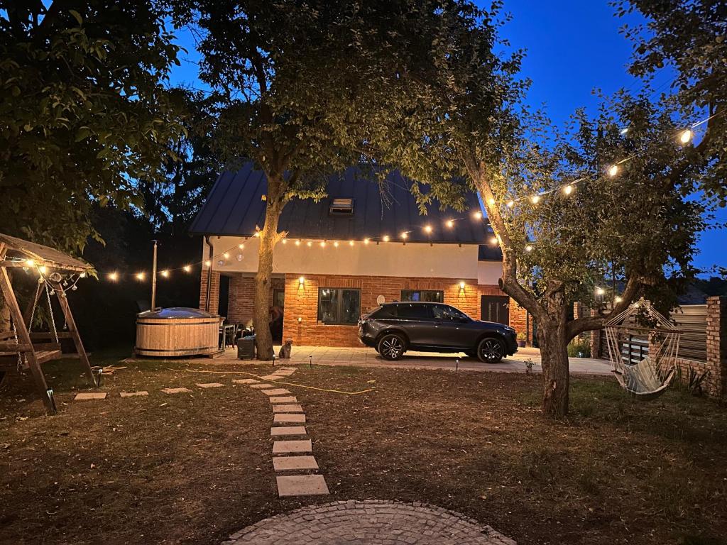a car parked in front of a house with lights at Dock Cottage House in Bădeni