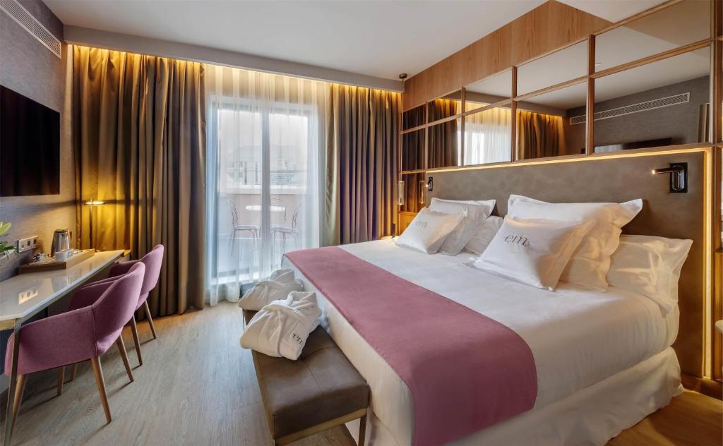 um quarto de hotel com uma cama grande e uma escrivaninha em Barceló Emperatriz em Madrid