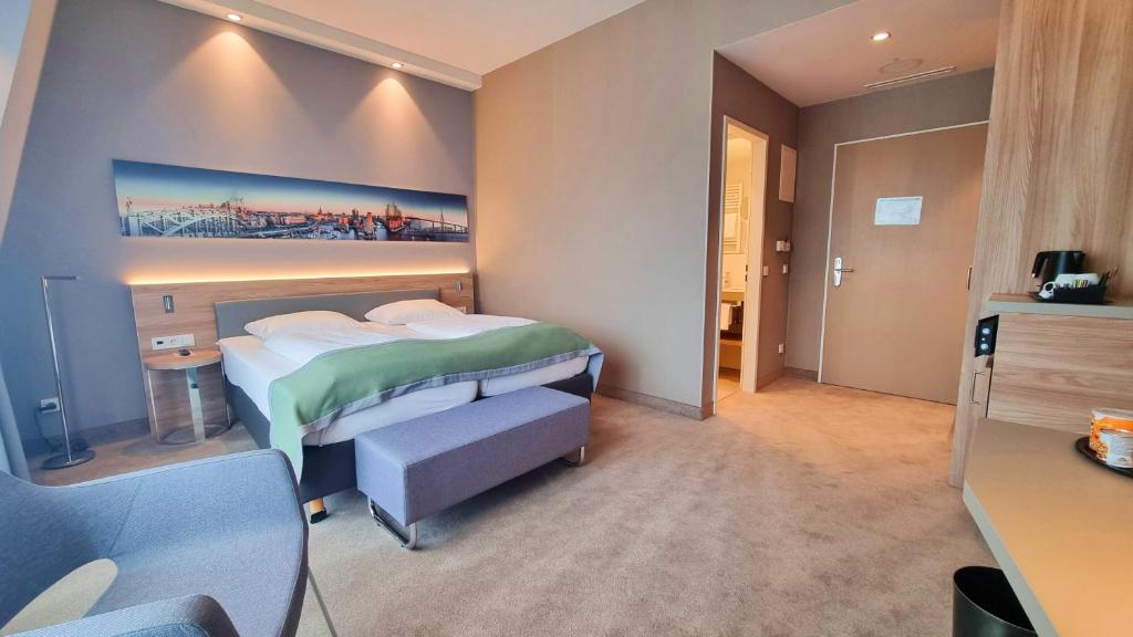 a hotel room with a bed and a desk at Hotel Panorama Hamburg-Harburg in Hamburg
