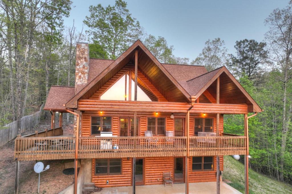 a log cabin with a wrap around deck at Sweet Seclusion Firepit king suite serene outdoor spaces in Mineral Bluff
