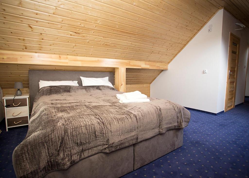 um quarto com uma cama grande e um tecto em madeira em Agroturystyka SzumyNowiny em Majdan Sopocki
