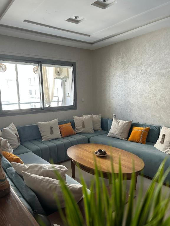 a living room with a blue couch and a table at Blue Space Malabata in Tangier