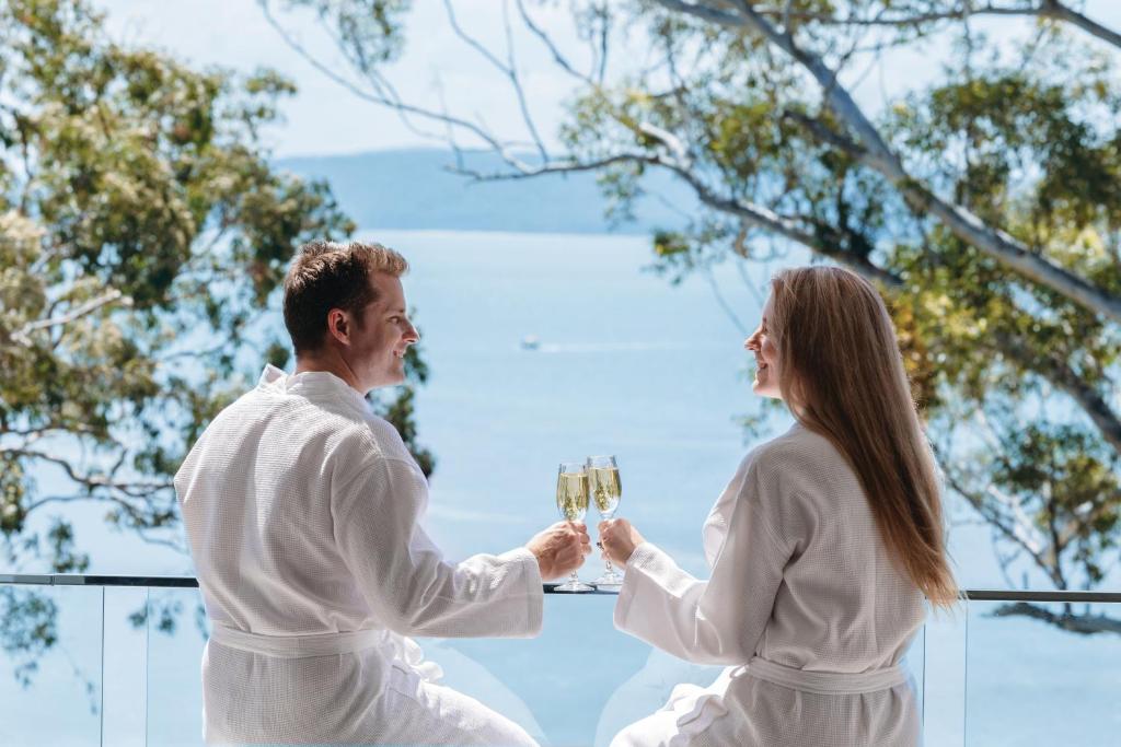 尼尔森湾Luxury Couples Escape - Vue One的一位男人和女人拿着香槟杯