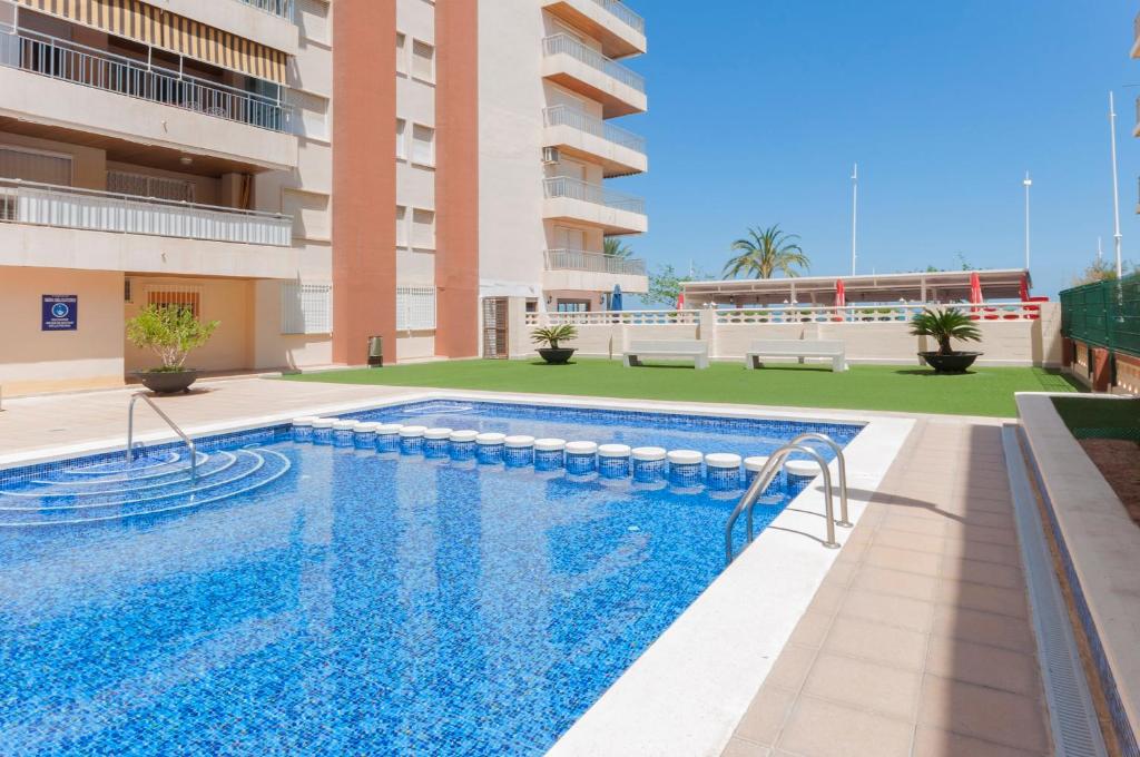 a swimming pool in front of a building at Piropo in Gandía