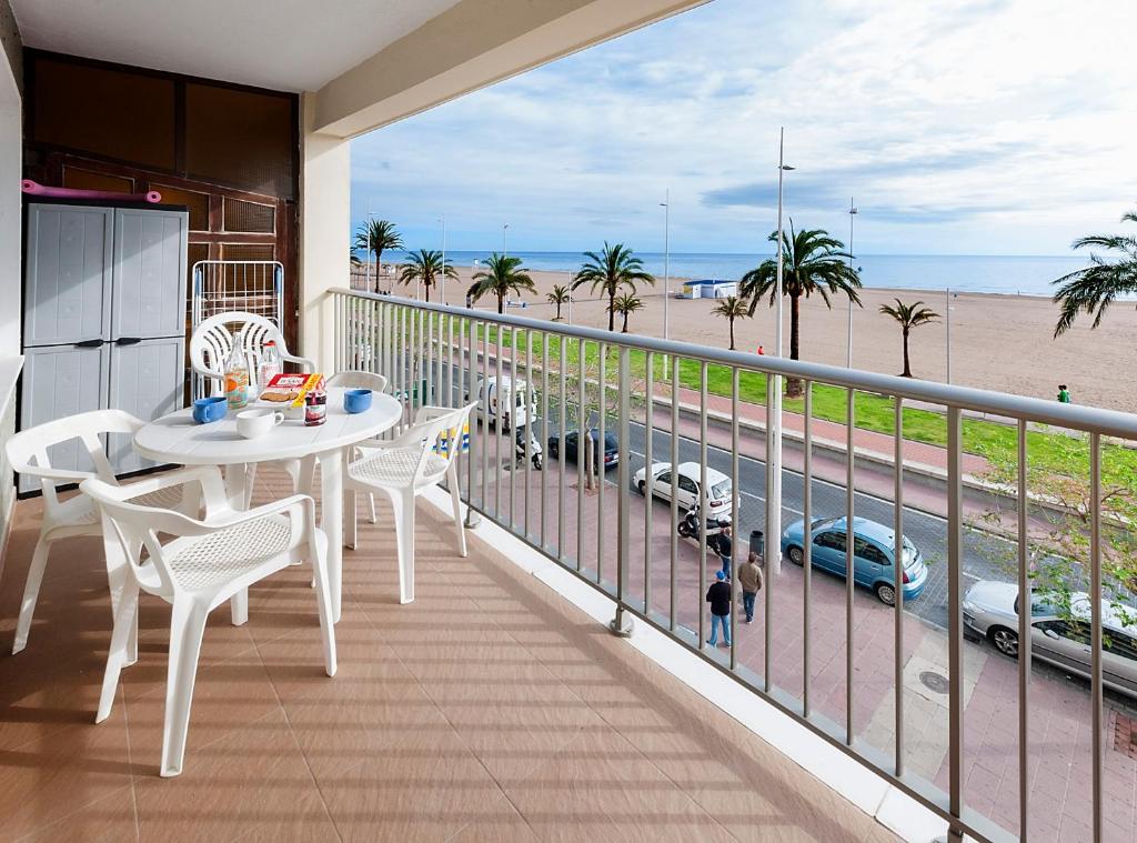 balcón con mesa y sillas y vistas a la playa en Infante en Puerto de Gandía