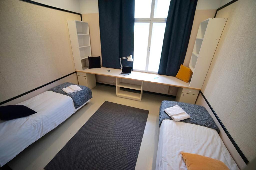 カウハバにあるLentoHotelliのベッド2台と窓が備わる小さな客室です。