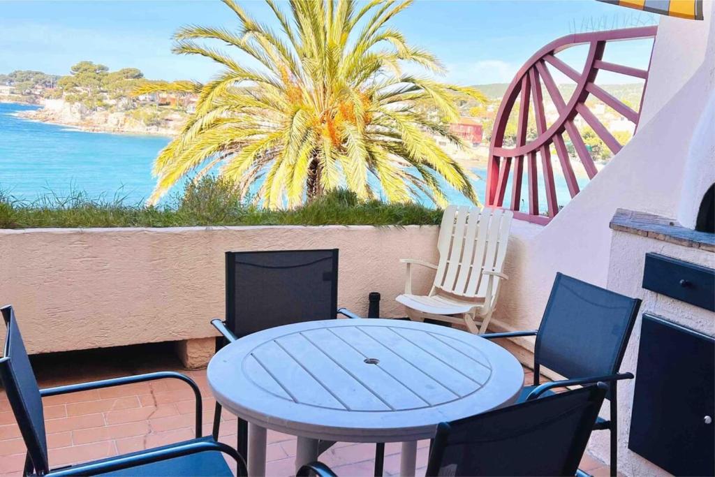 une table et des chaises sur un balcon avec vue sur l'océan dans l'établissement Terrasse avec superbe vue mer & pieds dans l’eau, à Bandol