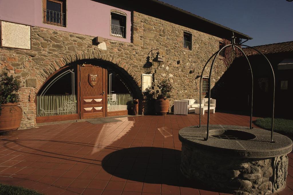 un bâtiment en briques avec une fontaine devant lui dans l'établissement Antica Locanda San Leonardo 1554, à Ghivizzano
