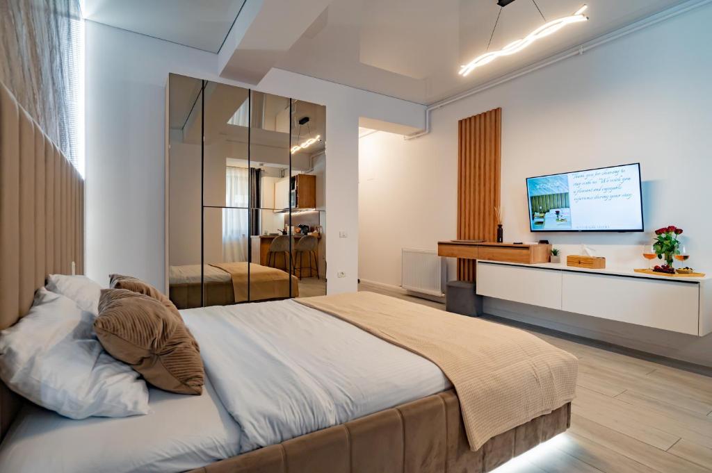 een slaapkamer met een groot bed en een televisie bij Sea Paradise Studio in Mamaia Nord – Năvodari