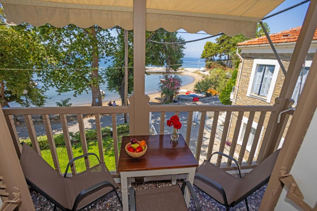 Ein Tisch und Stühle auf einem Balkon mit Blick auf das Meer in der Unterkunft Afissos Blu Hotel in Áfissos